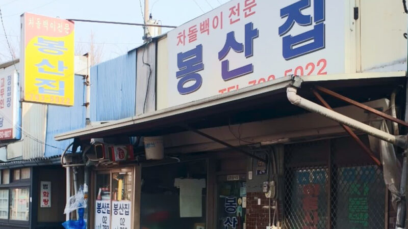 봉산집 외관과 골목 앞 간판이 보이는 모습
