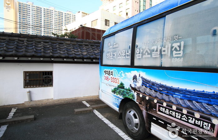 해운대암소갈비집의 긴 담장과 기와 지붕이 보이는 외관 전경