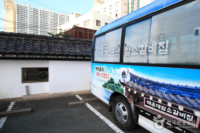 해운대암소갈비집의 긴 담장과 기와 지붕이 보이는 외관 전경