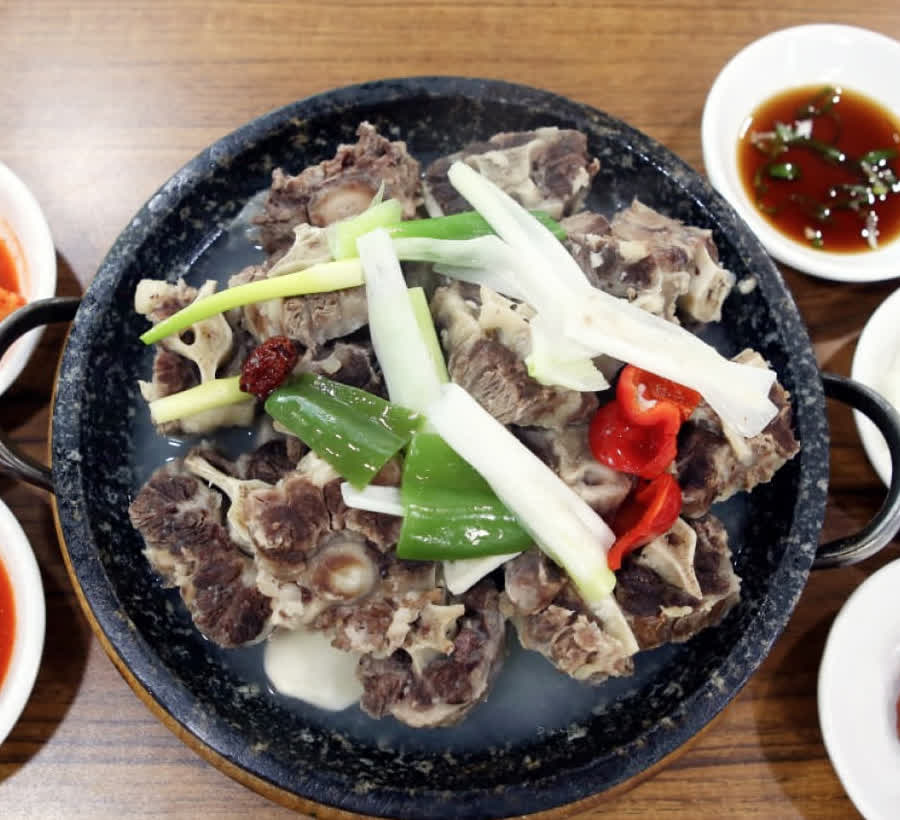 문화옥 설렁탕 국물과 고기 고명이 가까이 보이는 장면
